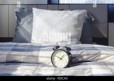 Classic Style Wecker am Bett mit Bettwäsche Interieur Schlafzimmer Stockfoto