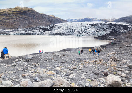 21. April 2018: South Island - Touristen am Solheimajokull Gletscherzunge und Gletschersee. Stockfoto