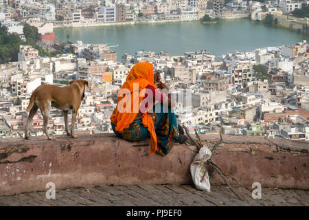 Frau und Hund lookin Gicht über Tal und Katora Stadt Jaipur, Rajasthan, Indien Stockfoto