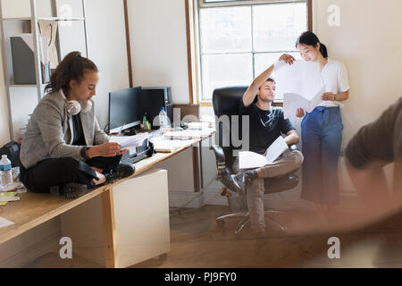 Kreative Geschäftsleute diskutieren Papierkram im Büro Stockfoto