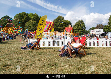 Bristol, UK: August 09, 2018: Touristen entspannen Sie mit einem erfrischenden Thatchers Apfelwein aus einer Konzession stand an der Bristol International Balloon Fiesta. Stockfoto