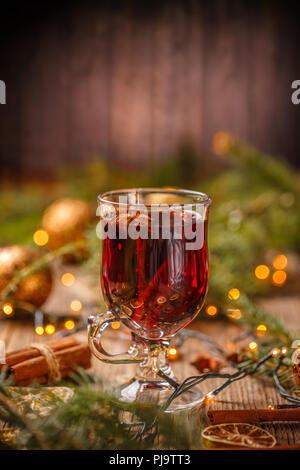 Glas mit heissen roten Wein und Gewürzen auf Weihnachten Hintergrund Stockfoto