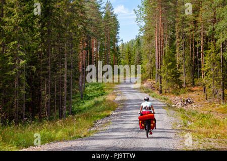 Reisen Radfahrer reitet ein Radweg entlang der malerischen Schotterweg durch Fichtenwald im südlichen Norwegen Stockfoto