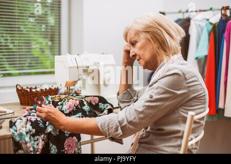 Erwachsene Frau näht in Ihrem Studio. Sie ist frustriert, weil sie einen Fehler gemacht. Stockfoto