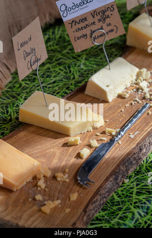 Käse zum Verkauf auf einen Stall in Stroud Farmers Market. Stroud, Gloucestershire, England Stockfoto