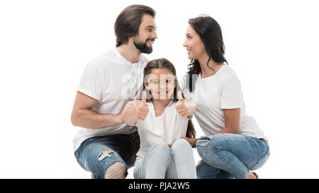 Portrait von lächelnden Kid mit Daumen hoch mit den Eltern hinter auf Weiß isoliert Stockfoto
