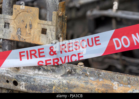 Brand beschädigt Auto zeigt die Fire & Rescue Service Nicht kreuzen Kunststoffband. Stockfoto