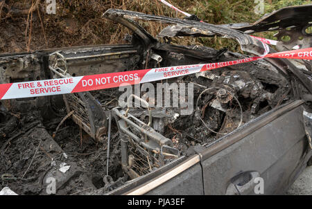 Brand beschädigt Auto zeigt die Fire & Rescue Service Nicht kreuzen Kunststoffband. Stockfoto