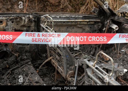 Brand beschädigt Auto zeigt die Fire & Rescue Service Nicht kreuzen Kunststoffband. Stockfoto