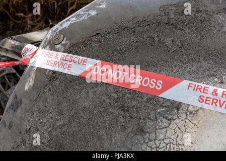Brand beschädigt Auto zeigt die Fire & Rescue Service Nicht kreuzen Kunststoffband. Stockfoto