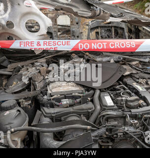 Brand beschädigt Auto zeigt die Fire & Rescue Service Nicht kreuzen Kunststoffband. Stockfoto