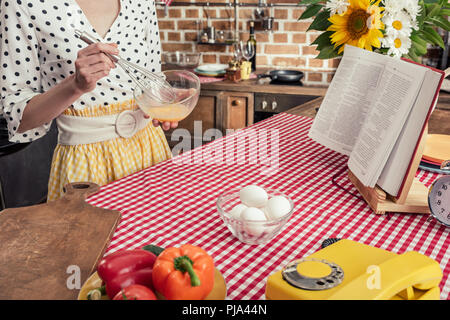 7/8 Schuß von hausfrau rühren, Eier für Omelette in Küche Stockfoto