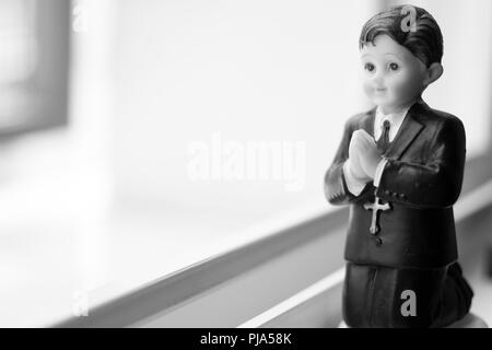 Cake Topper katholische Heilige Kommunion Zeremonie religiöse Junge zum christlichen Gott in der Kirche zu beten. Stockfoto