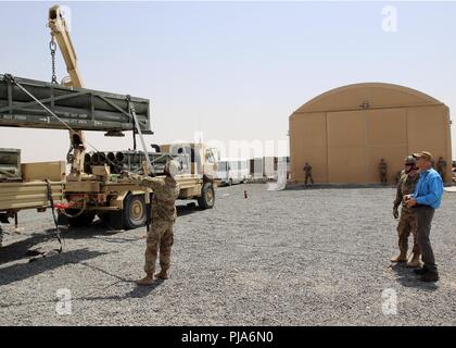 CAMP BUEHRING, Kuwait - Florida reg. Rick Scott (rechts) betreibt einen Kran in das Neuladen der High Mobility Artillery Rocket System (HIMARS) Juli 3, 2018 verwendet. Er reiste nach Kuwait Soldaten mit Bravo Batterie, 3.BATAILLON, 116 Field Artillery Regiment, Florida nationalen Schutz, der im Januar mobilisiert zu erfüllen. Scott Unterstützung ist Spc. Cody Beeson des Lake Wales, Fla. Sgt. Darius Williams, Haines City, Florida ansässig ist, leiten Sie die Last auf dem Anhänger. Stockfoto