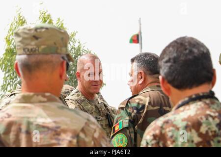 KANDAHAR, Afghanistan (Juli 5, 2018) --U.S. Armee Brig. Gen. Jeffrey Smiley, Links, Kommandierender General für Zug, Beraten und Unterstützen Command-South, Gespräche mit afghanischen Armee Brig. Gen. Abdul Rahman Parwani, rechts, stellvertretender Kommandant der 205th Corps afghanische Armee, rechts, 5. Juli 2018, nach der Abschlussfeier Eagle Strike Unternehmen im Camp Hero, Afghanistan. Eagle Strike Unternehmen ist eine neu gegründete Firma, die schnelle Eingreiftruppe aus afghanischen Soldaten in den verschiedenen Brigaden der 205th Korps, um zu helfen, die Letalität der afghanischen nationalen Verteidigungs- und Sicherheitskräfte zu erhöhen. Stockfoto