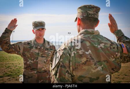 2. Lt Pierce Bäcker, um eine Co zugeordnet, 2 Battalion, 5th Cavalry Regiment, 1st Armored Brigade Combat Team, 1.Kavallerie Division, rezitiert die Amtseid während seiner Promotion Zeremonie, Novo Selo, Bulgarien, 2. Juli 2018. Baker wurde in den Rang eines Oberleutnant vom Kapitän Nicholas Spicocchi, Kommandeur der 2-5 Cav, 1 ABCT, 1 CD, während seiner Promotion Zeremonie. Gefördert Stockfoto