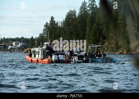 Der Küstenwache boot Besatzung zieht neben einem entspannenden Fischereifahrzeug auf See Coeur d'Alene, Idaho, 1. Juli 2018. Die Küstenwache Crews, in Partnerschaft mit den Kootenai County Sheriff Stellvertreter, arbeitete die Sicherheit der Schifffahrt Öffentlichkeit während der Feierlichkeiten zum 4 Juli zu gewährleisten. Stockfoto