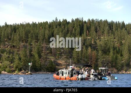 Der Küstenwache boot Besatzung zieht neben einem entspannenden Fischereifahrzeug auf See Coeur d'Alene, Idaho, 1. Juli 2018. Die Küstenwache Crews, in Partnerschaft mit den Kootenai County Sheriff Stellvertreter, arbeitete die Sicherheit der Schifffahrt Öffentlichkeit während der Feierlichkeiten zum 4 Juli zu gewährleisten. Stockfoto