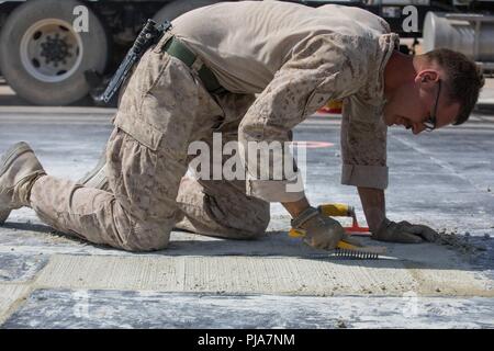 Unbekannten ORT, NAHER OSTEN - US Marine Corps Cpl. Seth Brummer, eine Bekämpfung der Ingenieur mit Marine Wing Support Squadron 371, Special Purpose Marine Air-Ground Task Force angebracht, Krise Response-Central Befehl reinigt aus einem Abschnitt der Zement während der Reparatur eines beschädigten Flugplatz Juli 3, 2018. Der Flugplatz Schäden reparieren Team sorgt für Start- und Landebahnen sicher sind Flugbetrieb in der gesamten Region durchzuführen. Stockfoto