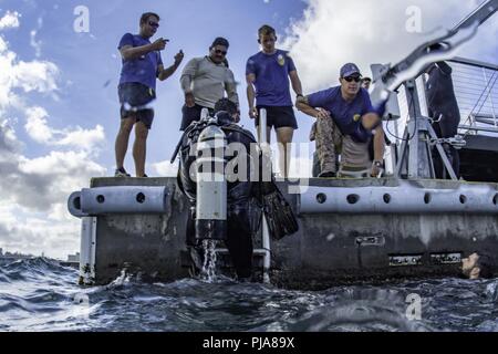 JOINT BASE Pearl Harbor - HICKAM, Hawaii (6. Juli 2018) der US-Marine Taucher, auf Mobile Tauchen retten (MDSU) 1 und der Royal Australian Navy Taucher verlassen Sie das Wasser nach dem Tauchgang auf der USS Arizona Memorial Abschluss von Joint Base Pearl Harbor-Hickam während der Rand des Pazifik (Rimpac) Übung zugewiesen. 25 Nationen, 46 Schiffe, 5 U-Boote, über 200 Flugzeuge und 25.000 Angestellte beteiligen sich an Rimpac vom 27. Juni bis 2. August in und um die hawaiischen Inseln und Südkalifornien. Die weltweit größte internationale maritime Übung RIMPAC bietet eine einzigartige Ausbildung opport Stockfoto