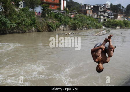 Kathmandu, Nepal. 5. Sep 2018. Ein Junge Tauchgänge aus einer hohen Mauer in der bagmati River an einem heißen Tag in Kathmandu, Nepal. Credit: Skanda Gautam/ZUMA Draht/Alamy leben Nachrichten Stockfoto