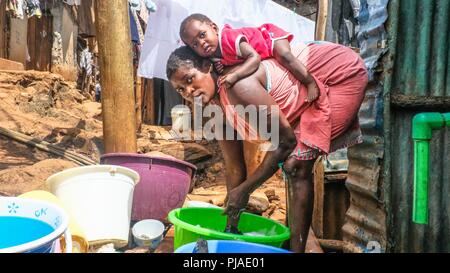 Nairobi, Kenia. 28. März, 2018. Keisha komfortabel Festlegung auf der Rückseite ihrer Mutter als ihre Mutter gesehen hat die Wäsche in Kibera. Kibera ist einer der größten Slums in Afrika Ostafrika, Kenia befindet. Credit: Donwilson Odhiambo/SOPA Images/ZUMA Draht/Alamy leben Nachrichten Stockfoto