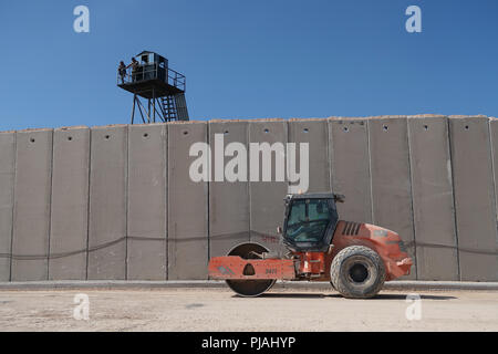 Rosh Hanikra, ISRAEL. 5.. September 2018. Mitglieder der libanesischen Streitkräfte stehen vor einem Wachturm, während sie von der libanesischen Seite der Grenze auf eine israelische Straßenrollerplanungsfläche entlang der neuen, sieben Meter hohen, verbesserten Sicherheitsmauer blicken, die Israel an der israelisch-libanesischen Grenze in der Nähe des Rosh Hanikra Crossings, auch bekannt als, errichtet hat Ras Al Naqoura Crossing. Die Betonmauer wird auf israelischem Territorium errichtet und wird sich vom Mittelmeer im Westen bis zum Gebiet um den Berg Hermon im Osten erstrecken. Kredit: Eddie Gerald/Alamy Live Nachrichten Stockfoto