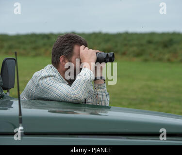 Mann mit Fernglas während der Pirsch Stockfoto