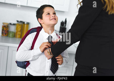 Teilansicht von Mutter und Sohn in der Schule Uniform mit Rucksack in der Küche zu Hause, zurück in die Schule Konzept Stockfoto