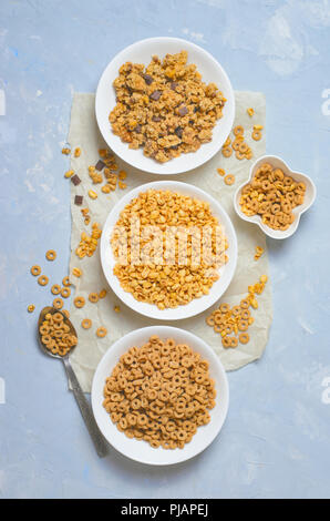 Verschiedene Arten von Getreide, schnelles Frühstück, gesunde Snacks, Puffreis, Müsli Loops und Schokolade Müsli Stockfoto