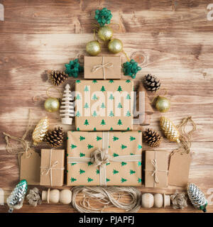 Ansicht von oben braun Weihnachtsgeschenk Boxen in Anordnung, mit funkelnden geprägte Fell Bäume, Tannenzapfen, goldene Kugeln, Holzdekorationen, Jute twin Stockfoto