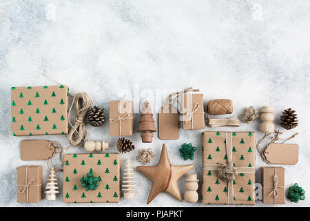 Weihnachten arrangement, Braun vorhanden Boxen mit funkelnden geprägte Tannen, Tannenzapfen, Holzdekorationen, Jute Garn, Ansicht von oben, auf dem Licht hinterg Stockfoto