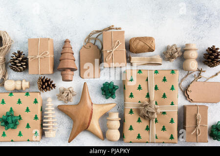 Weihnachten arrangement, Braun vorhanden Boxen mit funkelnden geprägte Tannen, Tannenzapfen, Holzdekorationen, Jute Garn, Ansicht von oben, auf dem Licht hinterg Stockfoto