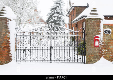 Viktorianische Eisen Tore zu einem großen englischen Haus im Schnee zu Weihnachten Stockfoto