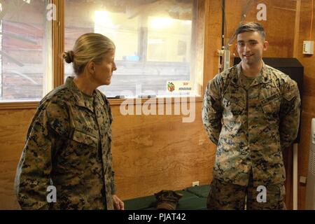 Us Marine Generalmajor Helen G. Pratt, 4. Marine Logistics Group kommandierender General, lobt Sgt. Alexander Wiese, eine Bekämpfung der Ingenieur mit Special Purpose Marine Air-Ground Task Force - südliche Befehl, für seine harte Arbeit und Führung in die Verbesserung der Infrastruktur auf Lager Manion Soto Cano Air Base, 11. Juli 2018. Weiss und die Marines führte er mehrere Aufgaben, einschließlich der Verbesserung der strukturellen Integrität der Gebäude und die Verkleidung der Decken mit dampfsperren das tropische Klima von Honduras zu bekämpfen. Die Marinesoldaten und Matrosen von SPMAGTF - SC sind die Durchführung von Sicherheit Zusammenarbeit Schulung Stockfoto
