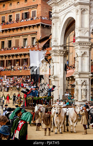 Der Palio Seide Banner ist rund um den Platz während der Corteo Storico (Historische Prozession) Auf der Piazza Del Campo, Palio, Siena, Italien vorgeführt Stockfoto