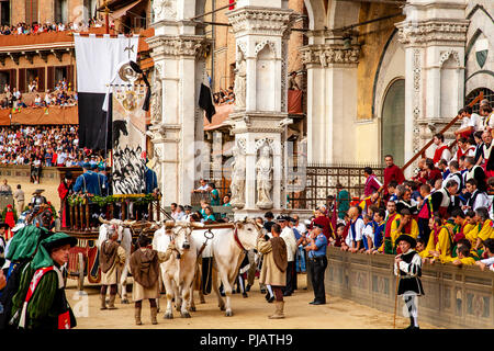 Der Palio Seide Banner ist rund um den Platz während der Corteo Storico (Historische Prozession) Auf der Piazza Del Campo, Palio, Siena, Italien vorgeführt Stockfoto