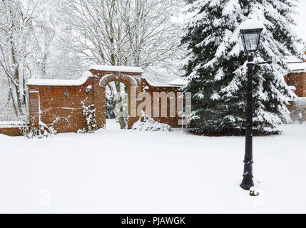 A Victorian walled garden und gemauerten Torbogen im Schnee im Winter Stockfoto