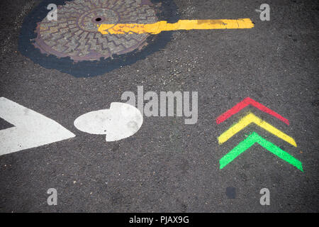 Rote, gelbe und grüne Pfeile auf pflaster gemalt Stockfoto