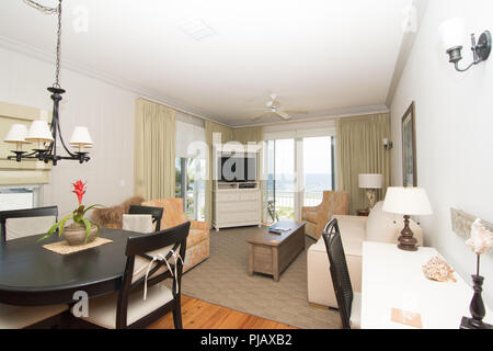 Ein geschmackvoll eingerichtetes Wohnzimmer mit Terrassentür mit Blick auf den Ozean. Stockfoto