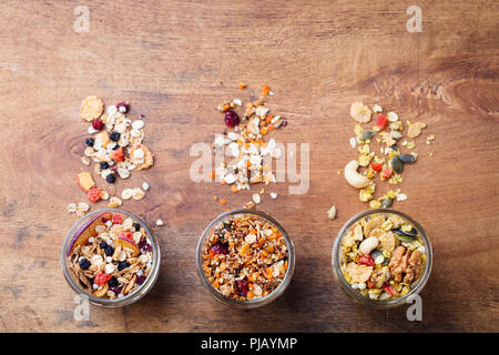 Auswahl an Müsli, in Gläsern Müsli. Bio Hafer mit Früchten, Beeren, Nüsse. Ansicht von oben. Kopieren Sie Platz. Stockfoto