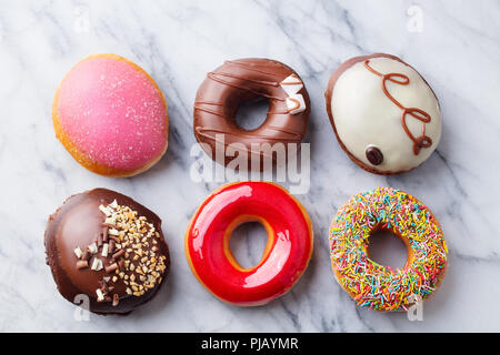 Auswahl an Donuts auf der marmortisch Hintergrund. Ansicht von oben. Stockfoto