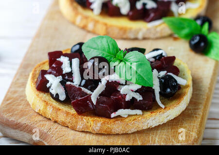 Bruschetta mit gebackenen Rüben, Blaubeeren, FETA-Käse, Basilikum und Balsamico. Gourmet Snack. Gesunde Ernährung. Selektiver Fokus Stockfoto