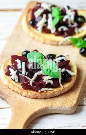 Bruschetta mit gebackenen Rüben, Blaubeeren, FETA-Käse, Basilikum und Balsamico. Gourmet Snack. Gesunde Ernährung. Selektiver Fokus Stockfoto