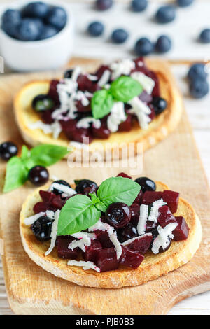 Bruschetta mit gebackenen Rüben, Blaubeeren, FETA-Käse, Basilikum und Balsamico. Gourmet Snack. Gesunde Ernährung. Selektiver Fokus Stockfoto