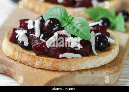 Bruschetta mit gebackenen Rüben, Blaubeeren, FETA-Käse, Basilikum und Balsamico. Gourmet Snack. Gesunde Ernährung. Selektiver Fokus Stockfoto