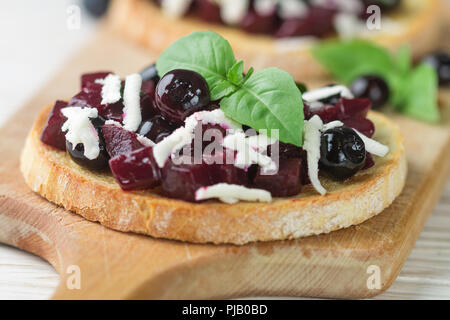 Bruschetta mit gebackenen Rüben, Blaubeeren, FETA-Käse, Basilikum und Balsamico. Gourmet Snack. Gesunde Ernährung. Selektiver Fokus Stockfoto