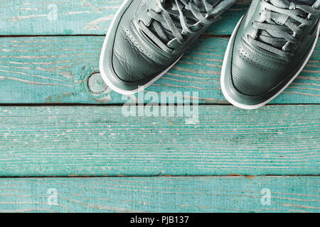 Grüne Sneakers auf grünem Hintergrund mit Kopie Raum Ansicht von oben. Herrenschuhe Stockfoto