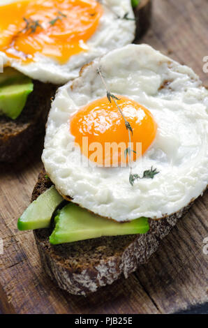 Gesundes Frühstück. Sandwich mit Roggenbrot, Avocado und Spiegelei. Stockfoto