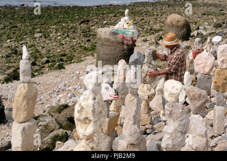 Mann an den Ufern des Flusses Tolgus Lissabon sculpting aus Steine am Strand Stockfoto